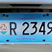 West End - Blick auf ein Nummernschild von Anguilla, dessen Wappen (drei Delfine) links zu sehen ist. Anguilla wird auch als "Rainbow City" bezeichnet, da es angeblich (fast) täglich Regenbögen gibt. Das nächste Foto bestätigt diese These...