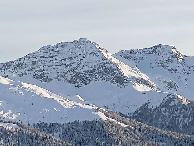 Auf einem Foto mit Hermann Hesse und Partnerin, das sie mit Skier über Arosa zeigt, sieht man diese beiden herangezoomten Berge.