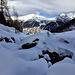 Knifflige Überquerung des tiefverschneiten Schweibbachs, am Horizont an der Sonne von rechts u.a. Fletschhorn, Äusser Rothorn, Gamserchopf, und nochmals Mattwald- und Simelihorn