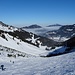 Bei der Abfahrt durch das Kar steigen zahlreiche Tourengeher noch im Sonnenschein auf