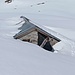 Mit Schnee zudecktes Alpgebäude