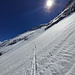 Auf guter Spur in griffigem Pulver Richtung Felsriegel mit dem Quergang, darüber unter der Sonne die obere NNE-Rippe