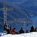 Eine Wandergruppe beim Mittagessen auf dem Monte Giove, auf der anderen Seeseite Maccagno