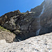 Rückblick vom Schneefeld zum grossen Wasserfall. Der Wanderweg kommt links entlang vom Grasband hinunter.