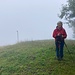 die Gipfeldame lächelt die wettermässig unfreundlichen Bedingungen weg