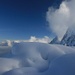 Blick über verschneite Latschen zum Gipfel