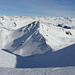Abfahrtsfreuden: Blick vom Tiejer Fürggli hinunter auf die rassige Abfahrt duch das Tälchen nach Norden. Am Horizont die Silvretta-Gipfel