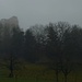Beim Schlossguet zeigen sich die Umrisse der Ruine Pfeffingen erstmals im Nebel.