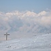 Das Wahrzeichen der Nonsalm: ein mächtiges Wegkreuz vor der Kulisse des frisch verschneiten Karwendels.