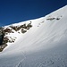 Die Felsinsel auf der das Bivaccio Rossi e Volante steht. Christoph fährt über den steilen Schneehang ab.