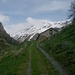 Bei der Alp Fless Dadoura (1954m) hat man erstmals einen Einblick ins Val Fless. In den Wolken zeigt sich der Piz Valtorta (2975m).