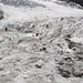 Fahnen und Stangen weisen den Weg über den ausgeaperten Gletscher
