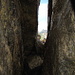 Durchschlupf hinter grossem Felsbrocken.