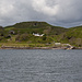 Blick hinüber nach Kerrera an der Anlegestelle. Man sieht den Weg nach Süden schwach. Auf dem besser sichtbaren Weg von den Häuser herunter kehrt man zurück