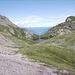 Il lago adagiato in una conca, sullo sfondo i monti della Val Sarentino