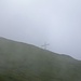 Das Gipfelkreuz des Rophaien hüllt sich in Nebel