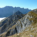 Gumpenspitze im Mittelgrund und Grubenkarspitze im Hintergrund. Über die Grashänge oberhalb der Abbrüche queren wir nach Süden