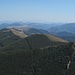 Das Rifugio Monte Cucco liegt am linken Bildran dversteckt im schattigen Wald; nur ein Teil der Zufahrtsstraße ist erkennbar.