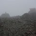 Ankunft bei Regen, starkem Wind bis 90km/h und Nebel auf dem höchsten Britischen Berg in Europa, dem 1344m hohen Ben Nevis / Beinn Nibheis.

Links ist der Vermessungspfosten auf dem höchsten Punkt, rechts die Nothütte und die Ruinen vom Observatorium.