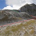 R. 310: Zuerst durchquert man die Südostflanke durch ein Geröllband, um dann durch ein steiles Geröllfeld bis zum Kamin aufzusteigen (rot). Anschliessend durchklettert man den Kamin (blau) oder - einfacher - man erreicht den Grat über ein weiteres Geröllfeld (grün). In fast direkter Linie erkraxelt man dann den Gipfel.
