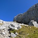 Diese Geröllhalde überquert man und steigt entlang der markanten Felswand auf guten Trittspuren auf, wo man das ausgesetzte Grasband erreicht, welches im Bild gesehen rechts hinaufführt.