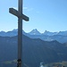 Das Gipfelkreuz des Schibengütsch mit den Berner Alpen im Hintergrund.