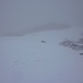 Der grosse Gipfelsteinmann auf dem Vanatsch (2478m) taucht im Nebel auf.