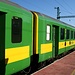 Die Schlierenwagen des Personenzugs 9122 glänzen im neuen grün-gelben Farbkleid.