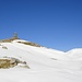 noch einmal im tieferen Schnee, dem mächtigen Steinmann, mit einem Pfahl zum Gipfelkreuz "aufgebessert, entgegen