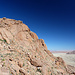 Rote Felsen weit über der Grasebene, die in die Namibdünen ausläuft