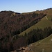 Foto unterhalb des Gipfels vom Tweralpspitz zu den beiden Gipfel der Chrüzegg: Links ist der Chümibarren (1313,9m), rechts der Chegelboden (1314m). Die während der kalten Jahreszeit verlassene Alphütte ist die Obere Tweralp (1249m).