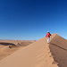 [U sglider] zeichnet die letzten Schritte zum höchsten Punkt in den unberührten Sandgrat - hoch über der endlosen Weite der Namib-Wüste