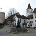 Auf dem Hauptplatz in Regensberg mit Turm, Kirche, Brunnen und Tannenbaum