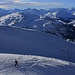 Aussicht vom Mutteristock (2294,0m) in die Urner Alpen während eine Snowboarderin dem Gipfel entgegen steigt.<br /><br />Die breite Kuppe ist die Silberen (2319m), dahinter ragt der Grosse Windgällen (3187,3m) in den Himmel.