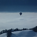 Ein Ballon erhebt sich über das Nebelgrau