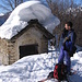 Fabiano davanti ad una cappella carica di neve a Selletto.