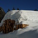 Viel Schnee liegt auf den Holzstämmen bei der Säge