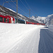 Bahn und Strasse von Schneemauern eingesäumt