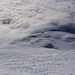 Tiefblick aus zirka 2500m aus der Flanke Calandsiten aufs Nebelmeer über dem Churer Rheintal. An der Nebelobergrenze erkennt man ganz klein die Calandahütte (2074m).