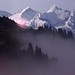 W&auml;hrend der Fahrt mit der Luftseilbahn zeigen sich die Gipfel der Berner Alpen &uuml;ber dem Nebel. Von links nach rechts sind <strong>B&auml;rglistock </strong>(3656 m), <strong>Rosenhorn </strong>(3689 m) und <strong>Wetterhorn </strong>(3692 m) zu sehen. Der Gletscher unter dem Wetterhorn ist der <strong>Rosenlauigletscher</strong>, der vom <strong>Dossen </strong>(3138 m) links und vom <strong>Wellhorn </strong>(3191 m) eingerahmt wird.