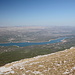 Gipfel Svilaja (Bat) - Teilpanorama 3 von 10. Ausblick in etwa nordöstliche/östliche Richtung u. a. auf den mittleren und südöstlichen Teil des Stausees Perućko jezero. Im Hintergrund sind teils noch mit Schnee bedeckte Berge in Bosnien und Herzegowina auszumachen.