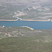 Gipfel Svilaja (Bat) - Tiefblick im Dunst hinunter zum Stausee Perućko jezero, mehr als 1.000 m unter uns. Vorn ist der Ort Maljkovo zu sehen, am gegenüberliegendem Ufer u. a. Dabar, südlich (rechts) des Seitenarms des Sees.