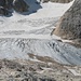 Gletscher (Ghiacciaio della Marmolada), links oben die Spuren der Bergsteiger auf dem Gletscher. Die Spuren führen nach rechts bis zu den Felsen, wo der Klettersteig beginnt.