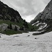 Das erste Schneefeld auf der Alp Tesel. Das erste Gipfelziel ist noch knapp zu erkennen.
