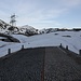 <b>Ore 5.55: inizia l'escursione.<br />La strada che sale in direzione dell’Alpe di Fortünéi è solo parzialmente coperta di neve: impossibile percorrerla con gli sci. Quattro sciatori tentano di aggirare il problema cercando dei canaloni innevati più a nord. Li ho visti arrancare sul ripido pendio e per finire hanno dovuto legare gli sci allo zaino.</b>