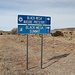 Östlich von Kenton - Wir sind richtig: Diese Wegweiser am Oklahoma State Highway 325 kündigen den Abzweig in Richtung "Black Mesa Nature Preserve" (Naturschutzgebiet) und "Black Mesa Summit" (Gipfel) an. Man beachte das "Bergsteiger-Symbol" auf dem unterem Schild. Rechts im Hintergrund sind bereits Ausläufer des Black Mesa zu erahnen.