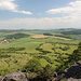 Gipfelbereich Bořeň - Ausblick u. a. auf Hrobčice (links). Der Ortsteil Chouč ist am rechten Bildrand nur zu erahnen (durch Gebüsch verdeckt).