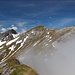 Blick von der Gamskarspitze auf den Gratverlauf zum Schlössl und Kaserjochspitze, die wie ein Schiffsbug aus den Wolken ragen