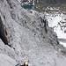 In der klettertechnischen Schlüsselstelle des Klettersteigs. Diese kommt bald nach der Rast (hinter dem Vorsprung, unter dem See, ist die Bank erkennbar)