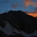 Mond und leuchtende Wolkenfetzen über dem Triglav (2864m).